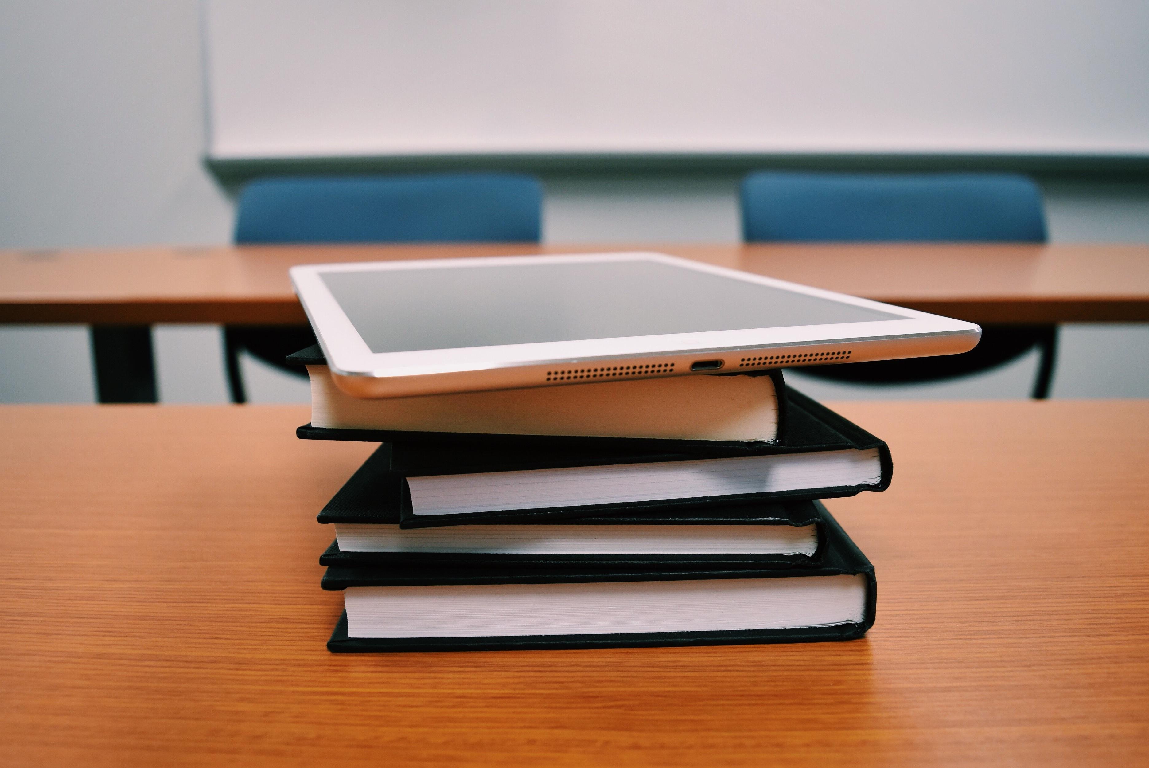 A tablet stacked on top of some books