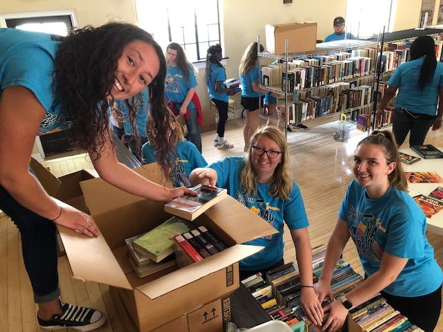 Day of Caring volunteers putting old books into boxes